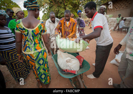 Small farmers receive sacks of seed and fertilizer at a distribution in Banfora Department, Burkina Faso. Stock Photo