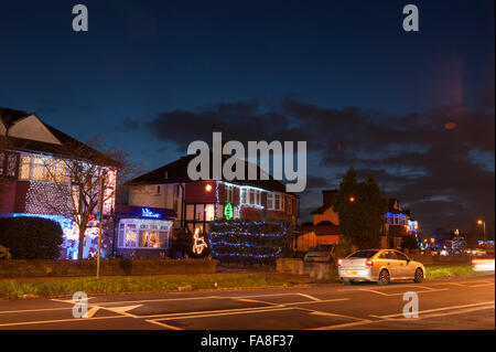 Lower Morden Lane, Surrey, UK. 23rd December, 2015. The residents of this suburban road decorate the exterior of their semi-detached houses with a riot of colourful christmas lights every year and accept donations from passing motorists and visiting locals to raise funds for local charities. Credit:  Malcolm Park editorial/Alamy Live News. Stock Photo