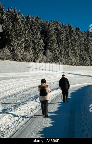 couple walking in winterlandscape on snow covered road in feldberg in germany Stock Photo