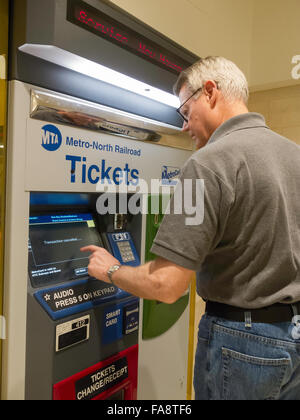 Man Purchasing Metro North Transit Train Tickets at Self Serve Vending Machine, Grand Central Terminal, NYC Stock Photo