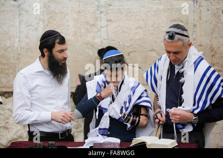 A young Jewish boy celebrates his Bar Mitzvah at the Western Wall also known as the Wailing Wall in Jerusalem, Israel. Stock Photo