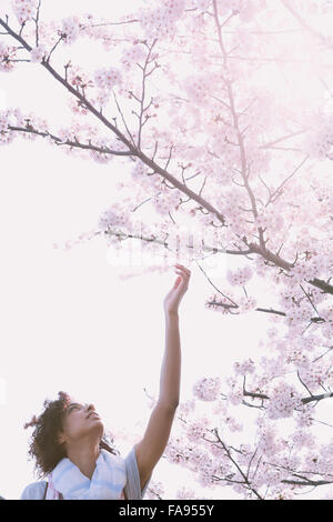 Young woman enjoying cherry blossoms blooming in Tokyo Stock Photo