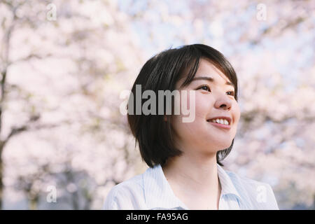 Young Japanese woman enjoying cherry blossoms blooming in Tokyo Stock Photo