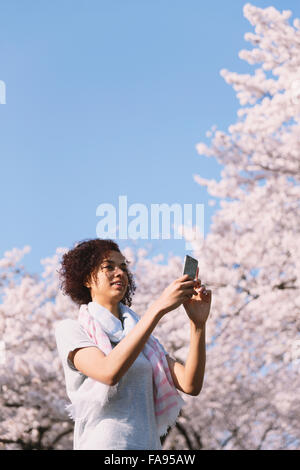 Young woman enjoying cherry blossoms blooming in Tokyo Stock Photo