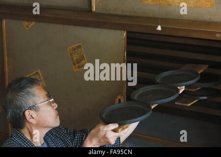 Japanese lacquer artisan working in the studio Stock Photo