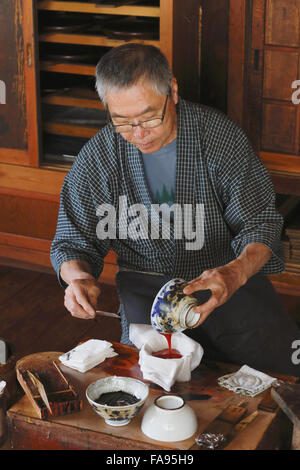 Japanese lacquer artisan working in the studio Stock Photo