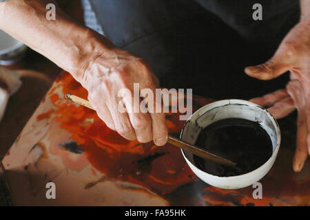 Japanese lacquer artisan working in the studio Stock Photo