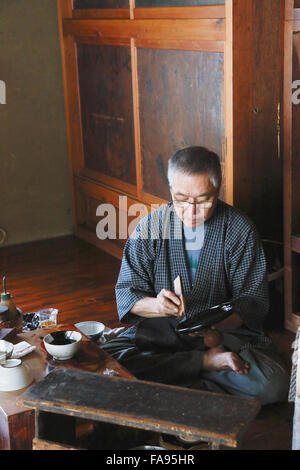 Japanese lacquer artisan working in the studio Stock Photo