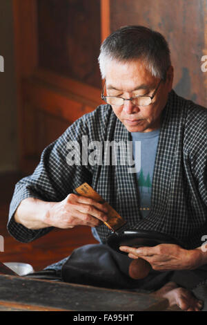 Japanese lacquer artisan working in the studio Stock Photo