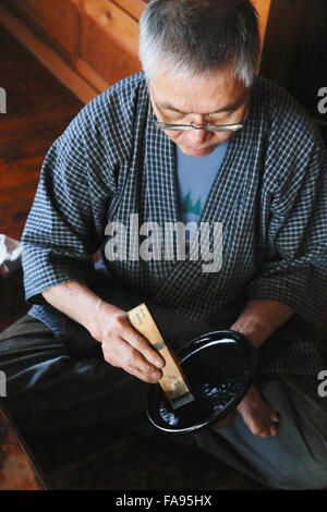 Japanese lacquer artisan working in the studio Stock Photo