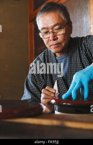 Japanese lacquer artisan working in the studio Stock Photo