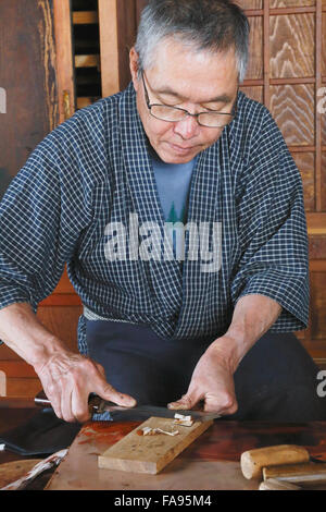 Japanese lacquer artisan working in the studio Stock Photo