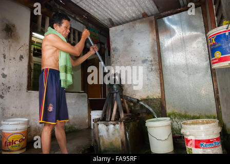 Residence of a dense neighborhood in Jakarta pumping waters from communal well. Stock Photo