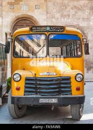 vintage armenian school yellow chevrolet bus in aleppo old town syria Stock Photo