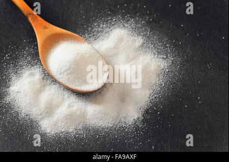 Bicarbonate in a wooden spoon on black background Stock Photo