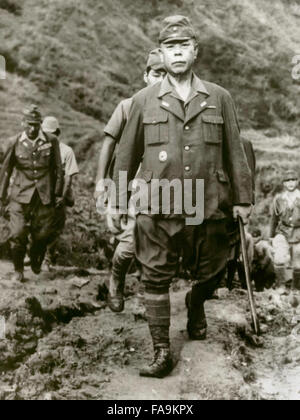 Tomoyuki Yamashita (1885-1946), Imperial Japanese Army general and his staff walk down the trail to U.S. forces in northern Luzon. From 29 October to 7 December 1945, an American military tribunal in Manila tried General Yamashita for war crimes relating to the Manila massacre and many atrocities in the Philippines and Singapore. The court found Yamashita guilty as charged and sentenced him to death. Photograph taken September 1945 following his surrender. Stock Photo