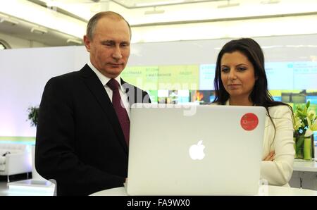 Russian President Vladimir Putin views a presentation with Editor-in-Chief of the Russia Today television Margarita Simonyan at the 10th anniversary exhibition of the network December 10, 2015 in Moscow, Russia. Stock Photo