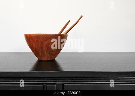 Kitchen utensils: empty wooden bowl with spoon and fork on black desk Stock Photo