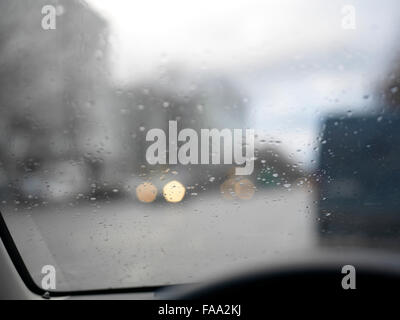 Close up of raindrops on a car windscreen, daytime shot with blurred background Stock Photo
