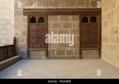 Stone brick wall with two embedded ornamented wooden cupboards at a terrace of a historic house in Old Cairo, Egypt Stock Photo