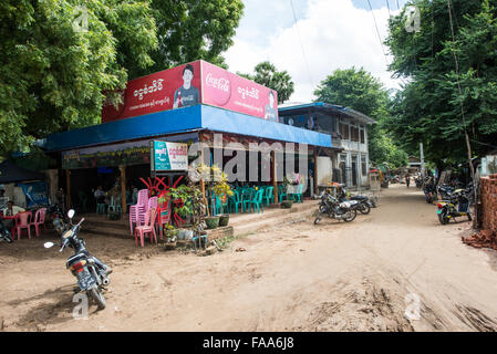 MYINKABA, Myanmar — Local vendors display fresh produce and goods at the morning market in Myinkaba village, near Bagan, Myanmar. Colorful fruits, vegetables, and traditional foods line makeshift stalls along the street. Stock Photo