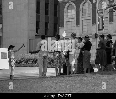 Extras on set awaiting the presidential motorcade in front of the Texas School Book Depository in Dallas, Texas. Stock Photo