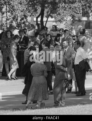 Extras on set awaiting the presidential motorcade in front of the Texas School Book Depository in Dallas, Texas. Stock Photo