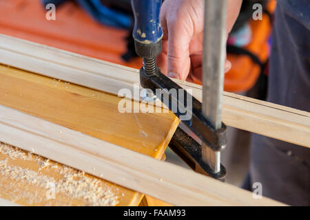 Carpenter working with doorjambs using electric circular saw Stock Photo