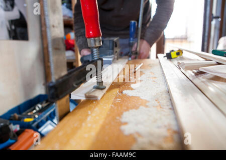 Carpenter working with doorjambs using electric jack plane on vertical position Stock Photo