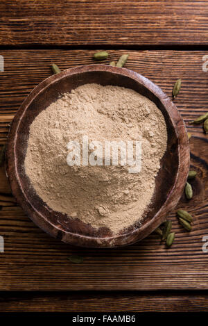 Portion of Cardamon Powder (close-up shot) on wooden background Stock Photo