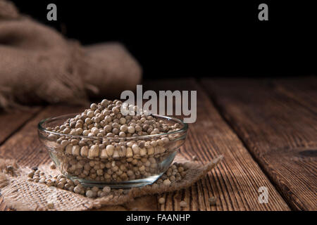 Some white Peppercorns (close-up shot) on wooden background Stock Photo