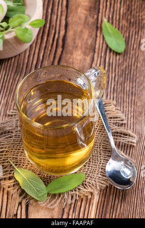 Sage Tea in a small glass on wooden background Stock Photo
