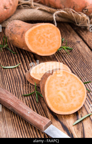Sweet Potato (uncooked) on vintage wooden background (close-up shot) Stock Photo