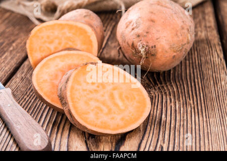 Sweet Potato (close-up shot) on rustic wooden background Stock Photo