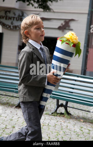 Boy, a first grader for the first time goes to school. Behind his back pack, in the hands of a package of sweets. This is Berlin Stock Photo