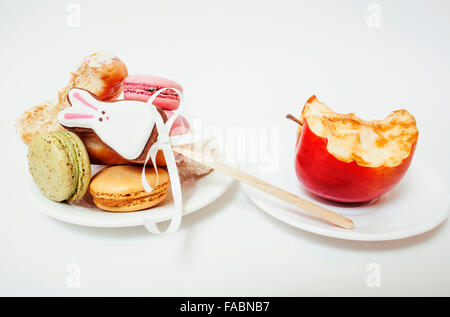 new diet concept, question sign in shape of measurment tape between red apple and donut isolated on white Stock Photo