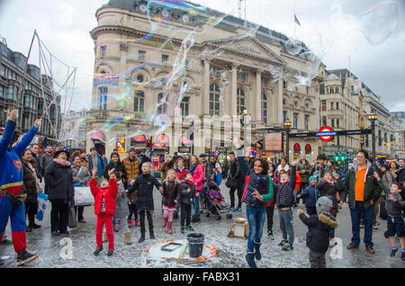 London, UK, 26 December 2015, Street entertainer in Piccadilly Circus with bubbles.  Boxing day shopping in Oxford Street as January sales start early. Credit:  JOHNNY ARMSTEAD/Alamy Live News Stock Photo