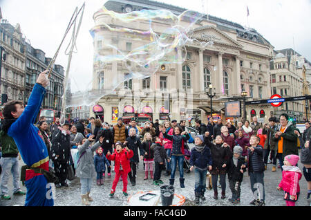 London, UK, 26 December 2015,  Street enterainer with bubbles entertains children at Piccadilly Circus.Boxing day shopping in Ox Stock Photo