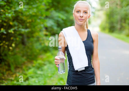 Smiling young woman having her break after running Stock Photo