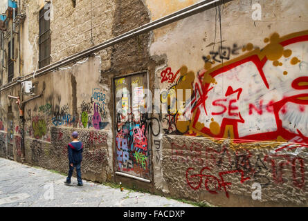 Ancient wall with graffiti on the street in historic center of Naples, Italy. Stock Photo