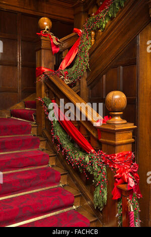 UK, England, Cheshire, Knutsford, Tatton Hall, red ribbon Christmas decorations on Family Entrance stairs Stock Photo