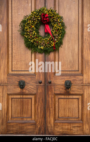 UK, England, Cheshire, Knutsford, Tatton Hall, traditional Christmas holly wreath on main door Stock Photo