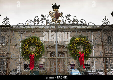 UK, England, Cheshire, Knutsford, Tatton Hall, traditional Christmas holly wreaths on gates to front door Stock Photo