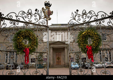 UK, England, Cheshire, Knutsford, Tatton Hall, traditional Christmas holly wreaths on gates to front door Stock Photo