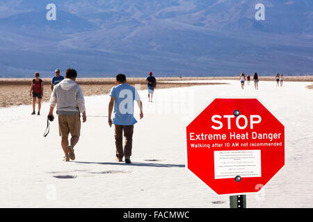 Tourists on salt pans Badwater in Death Valley which is the lowest, hottest, driest place in the USA, with an average annual rai Stock Photo