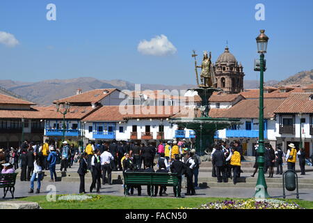 People gather around the base of the statue of Pachacuti in the Plaza de Armas, Cusco, Peru Stock Photo