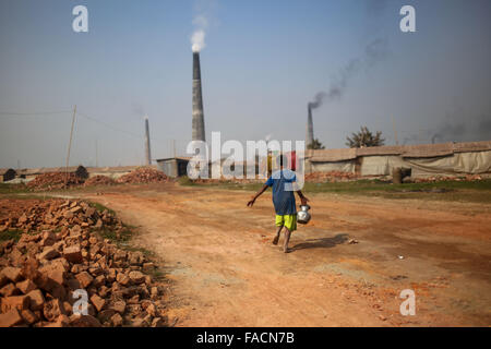 Dhaka, Bangladesh. 27th Dec, 2015. A child is carrying dringking water for brickyard worker.The world is going through a speedy urbanization and Bangladesh is not an exception from this. Such rapid urbanization generates a massive demand for bricks as it is one of the key ingredients to build concrete structure. To meet this growing need, numbers of brick making field have been increasing at an alarming rate in Bangladesh. Most of them took place in farming lands which causes reduction of agricultural production. Stock Photo