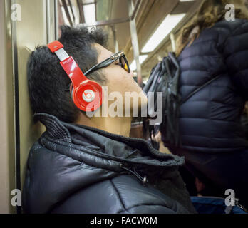 A music listener wears his Beats by Dr. Dre over the ear headphones during a subway ride in New York on Saturday, December 19, 2015. (© Richard B. Levine) Stock Photo