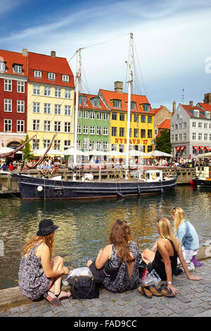 Turists relaxing at Nyhavn Canal, Copenhagen, Denmark Stock Photo