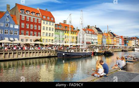 Turists resting at Nyhavn Canal, Copenhagen, Denmark Stock Photo